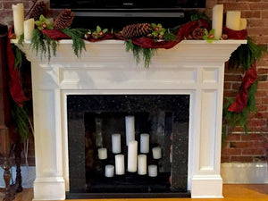 Christmas Fireplace Decorated with Ribbon and Pinecones and Candles