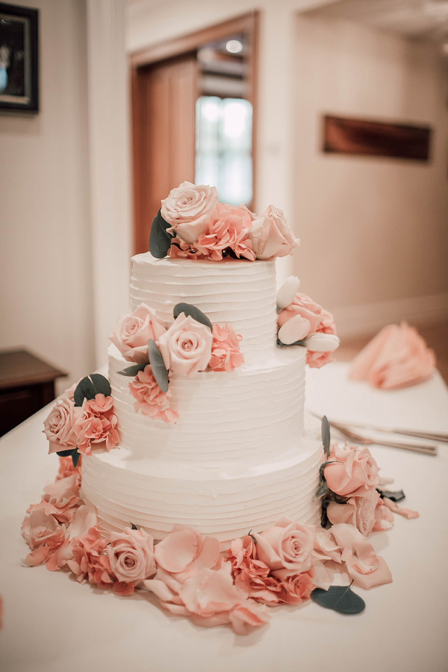Wedding Cake Flowers with Pink Hues, Silver Dollar Eucalyptus, Roses, and Rose Petals